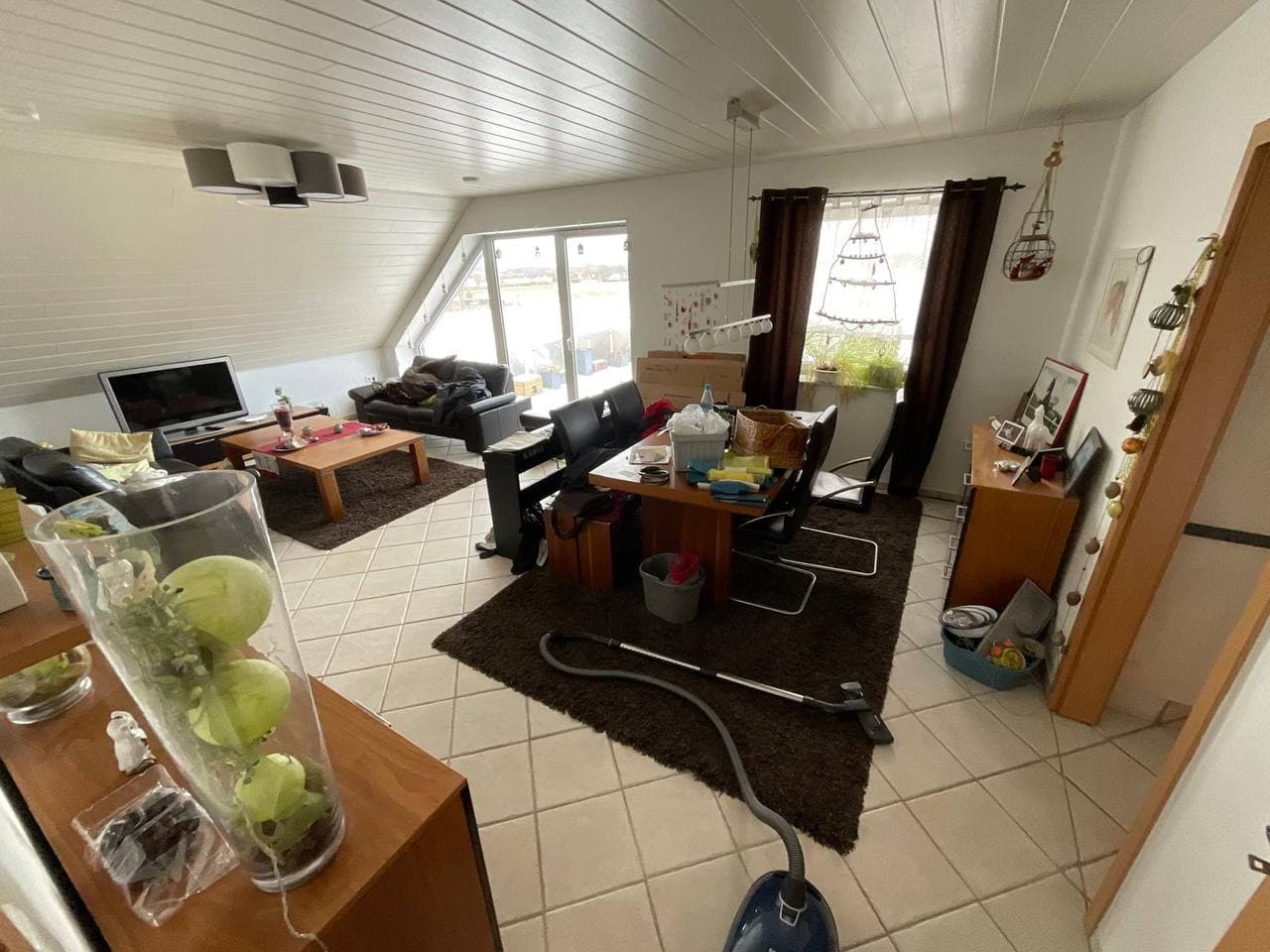 Eingerichtete Dachgeschosswohnung mit Esstisch und Wohnbereich vor der Auflösung
